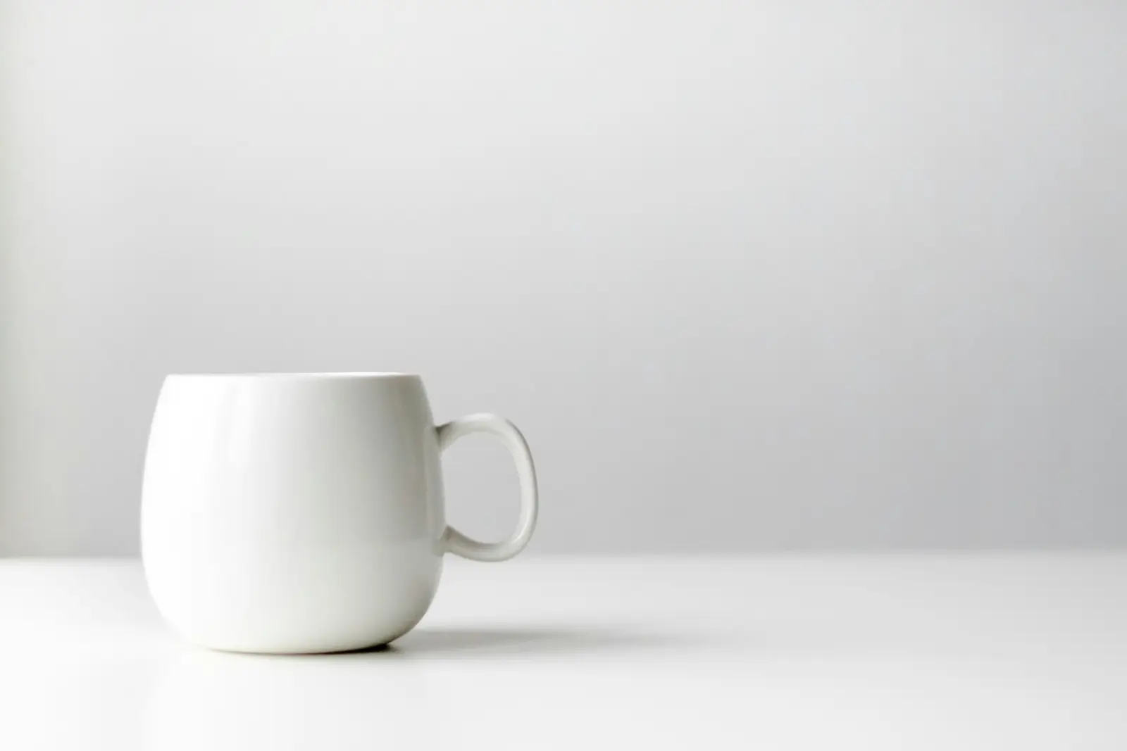 Mug keramik putih di atas meja putih